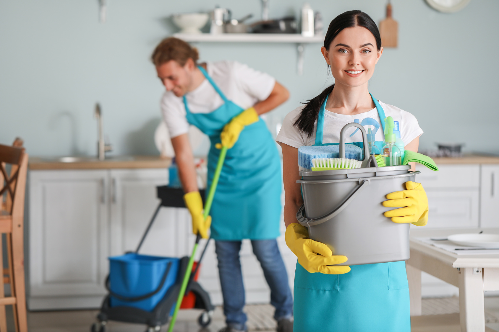 Cleaner with supplies preparing to clean a kitchen